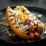 A homemade chili dog topped with cheese and onions