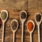 Various spices on wooden spoons.