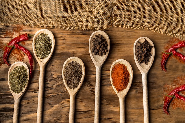 Various spices on wooden spoons.